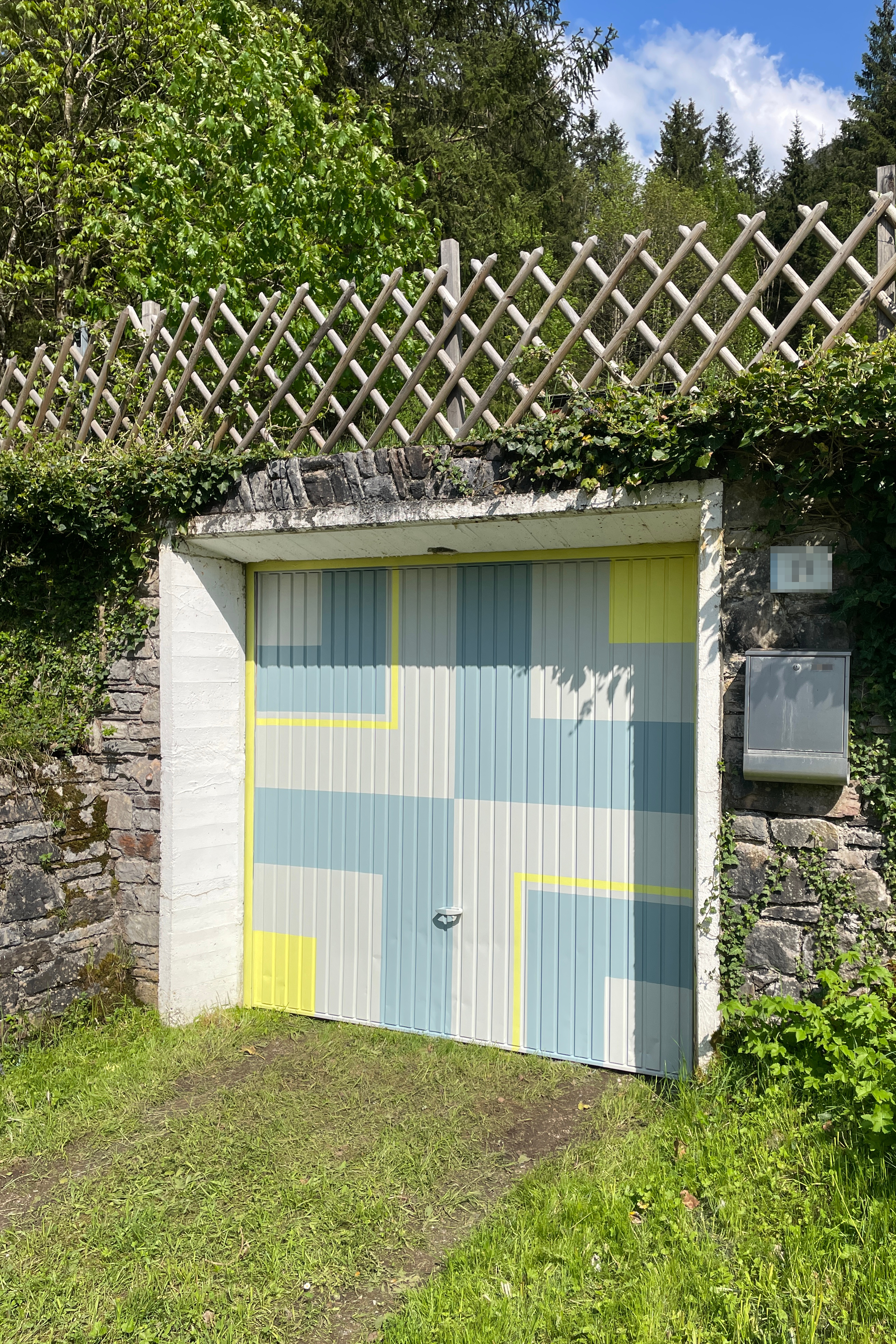 Garagentor mit geometrischem Muster in blau und gelb